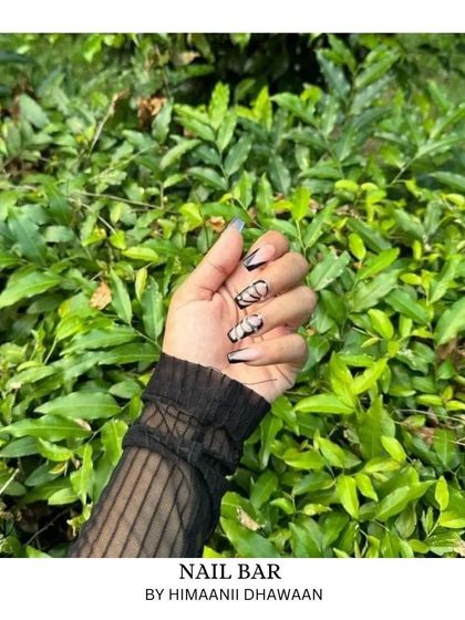A client posing with her new nails outdoors, showing how great they look in natural light.