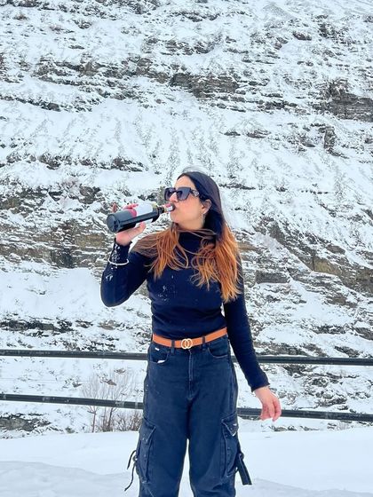 Taking a sip of wine in the snow. This kind of content is relatable and shows how to have fun, even in the cold.