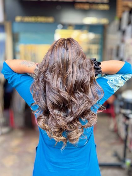 A soft blonde hair color achieved without bleach. This look adds gentle, warm highlights to a dark base for a subtle and natural-looking enhancement.