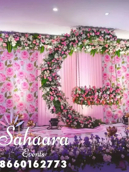 For a truly special naming ceremony or baby shower, we designed this breathtaking floral swing. The crescent moon shape, covered in soft pink and white flowers against a rose-patterned backdrop, creates a magical setting to welcome your little one.