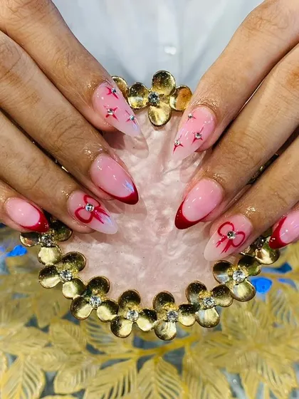 A cute and romantic red-themed set with French tips, bows, and tiny star accents.
