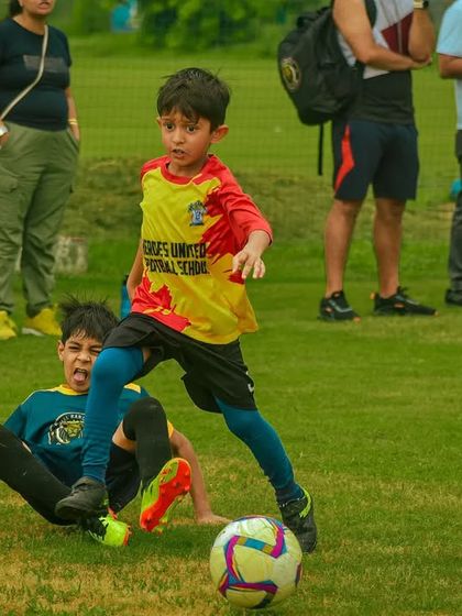 A player avoids a slide tackle while dribbling, showcasing quick reflexes and agility.