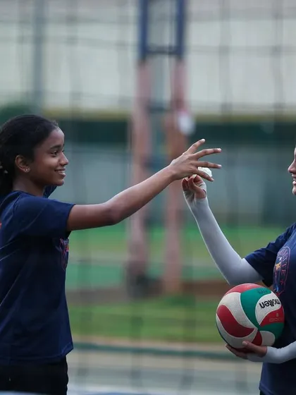 A teammate helps another with her hair clip mid-practice. It's these small moments of support that define our family culture.