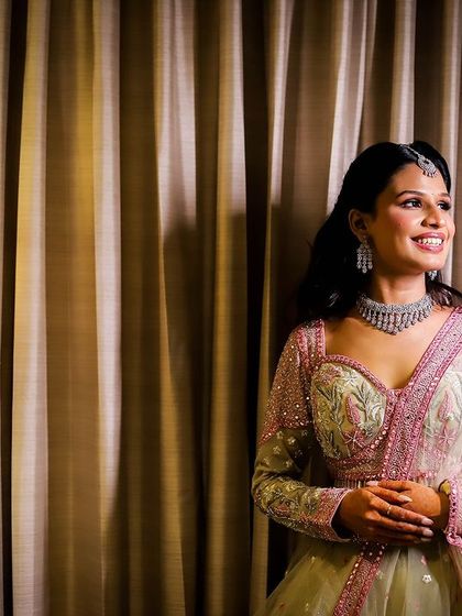 A portrait of a woman smiling, taken in a hotel room with soft, warm lighting.
