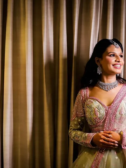 A portrait of a woman smiling, taken in a hotel room with soft, warm lighting.