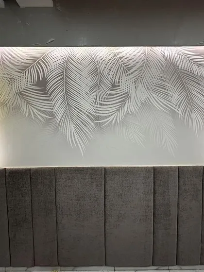 A finished view of the backlit wallpaper and upholstered headboard from a different angle. This detail is part of a complete bedroom design, creating a serene and visually appealing personal space.