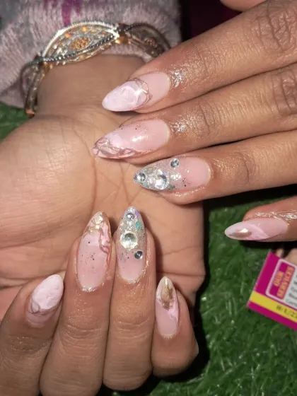 A close-up of the beautiful stone work on this pink marble nail set.