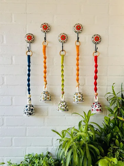 A beautiful set of five macrame ceramic bells in a mix of orange, green, and blue. These are perfect for adding a vibrant and artistic touch to your home, and you can customize the colors to your liking.