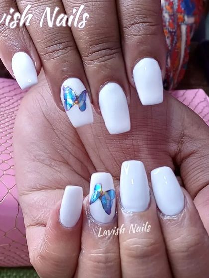 A simple set of white square nails with a beautiful, realistic blue butterfly sticker accent.