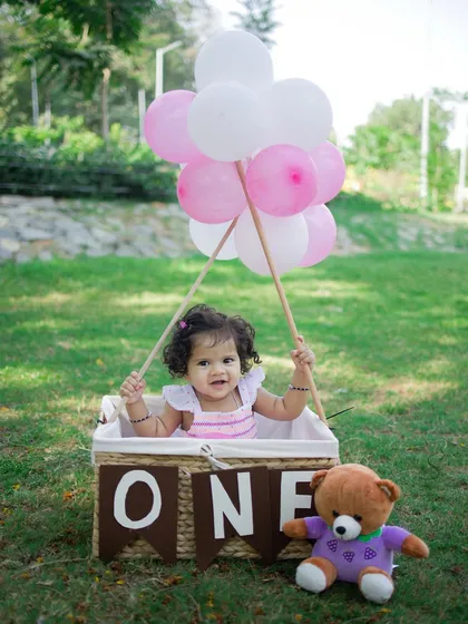 Up, up, and away. Outdoor sessions add a beautiful, natural element to your baby's portraits. This hot air balloon theme, set in a lovely park, is perfect for capturing a sense of wonder and adventure.