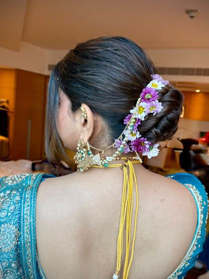 A side view of the floral updo, highlighting the intricate details of the hairstyle and the placement of the hair accessory.