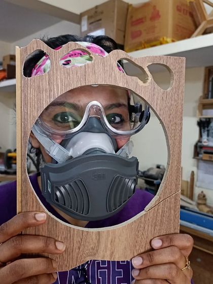 Safety and fun can go hand in hand. A student playfully peeks through her project while wearing her safety mask and goggles.