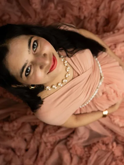 A beautiful high-angle shot looking directly at the camera. The soft folds of the peach gown create a lovely frame for this engaging portrait.