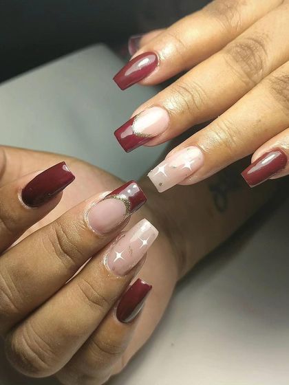 A festive design with a mix of deep red and a sheer nude base with star and moon glitter accents.