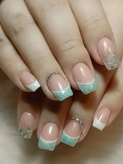 A fun take on the French manicure, with alternating white and sparkling mint green glitter tips, accented with rhinestones.