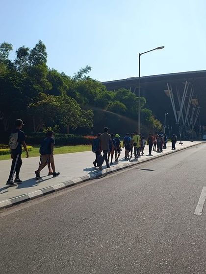 Participants walk towards the impressive structure of the Bengaluru airport terminal, part of their immersive learning experience.