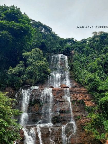 A different angle of Jhari Falls, showing its multiple cascades flowing over the rocky cliffside.