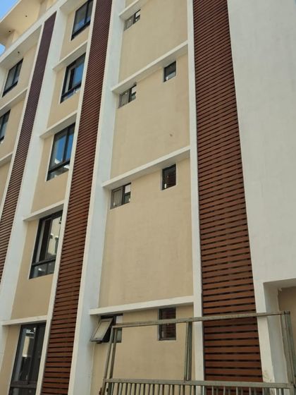 Another view of the wood-finish metal louvers, showing how they integrate seamlessly with the building's existing color scheme. Our solutions are designed to complement the architect's vision.