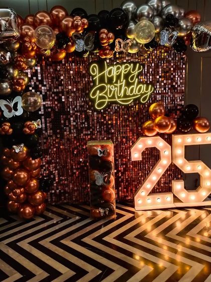 A rose gold sequin backdrop with black and copper balloons, perfect for a stylish 25th birthday party.