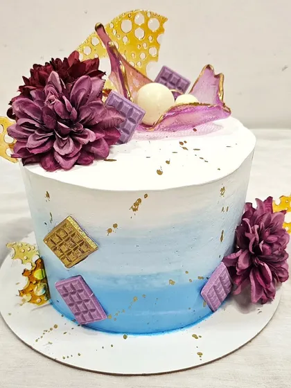 A modern cake with chocolate sails and floral decorations, another one of Prachi's creations from her class.