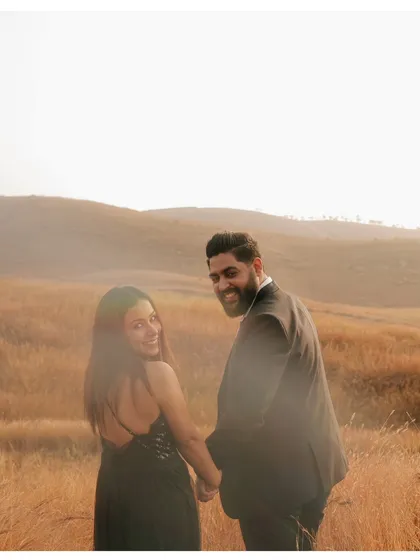 A classic "follow me" style shot, with the couple looking back with bright smiles, inviting you into their love story.