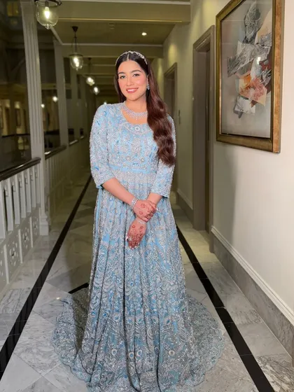 A grand entrance. The bride's makeup is flawless and radiant, ensuring she looks like royalty as she walks through the elegant corridor.