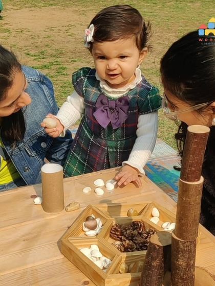 A toddler in our Cuddle Bugs program explores a tray of natural materials. These open-ended activities are perfect for stimulating curiosity and developing fine motor skills at their own pace.