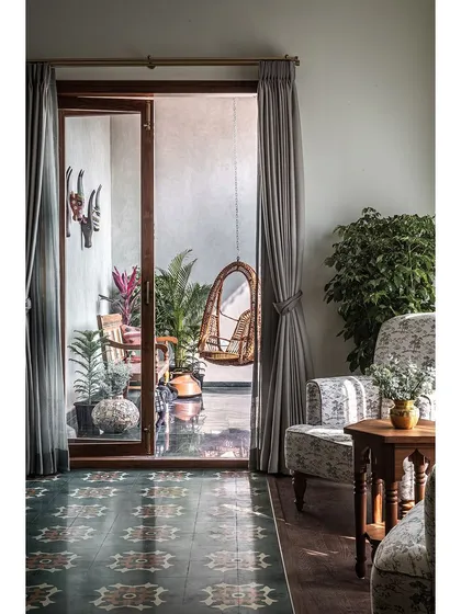 A glimpse from the master bedroom out to the balcony, where traditional design elements and lush greenery create a peaceful, private escape.