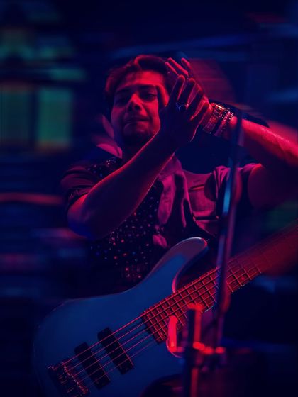 The bassist feeling the groove under the vibrant stage lights. Our performances are a visual and auditory treat, perfect for high-end events.