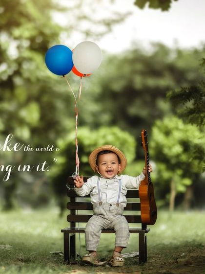 You make the world a little better by being in it. A joyful boy with a straw hat, ukulele, and balloons on a park bench.