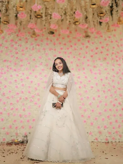 A happy client smiling in the white cape-sleeve lehenga. It's proof that you can feel like royalty without the royal price tag.
