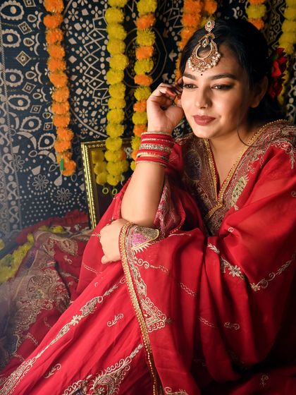 A client wearing a beautiful red outfit with a simple yet elegant maangtika from my collection.