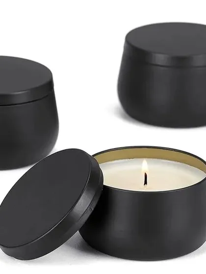 This image shows our matte black tin jars, one of which is filled with a lit candle. They are a versatile and popular option for candle makers.