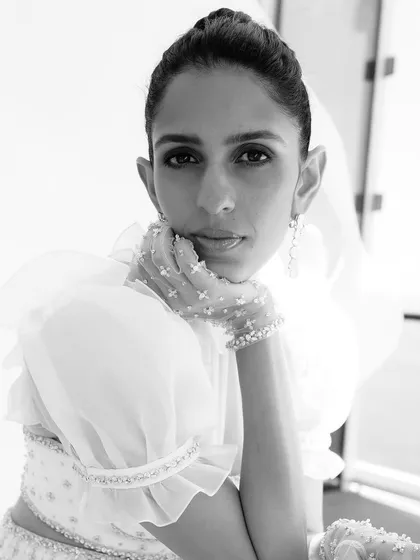 A close-up black and white portrait in the white Sabina Bilenko outfit, emphasizing its ethereal and high-fashion quality.