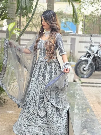 This shot shows the model holding the sheer dupatta, highlighting its lightness and the intricate border that matches the lehenga.