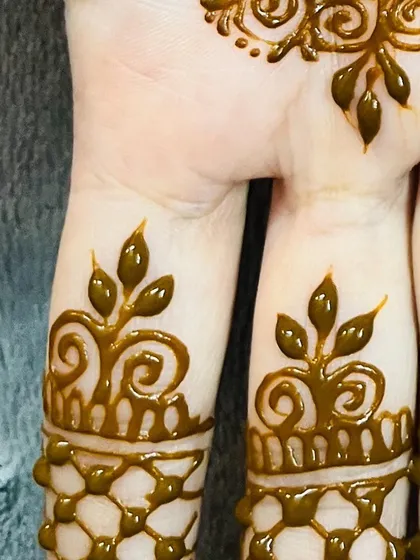 A close-up of some of the finger details I create. These small, leafy patterns are a great way to add a touch of henna without committing to a full hand design.