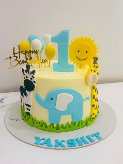 A sunny jungle-themed cake for a first birthday. The cheerful fondant animals like the elephant, zebra, and giraffe make it a happy and bright centerpiece.