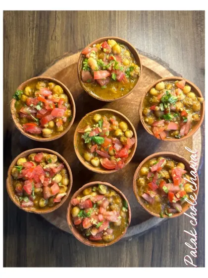 Kulhad wale Palak Chole Chawal. This unique chaat item serves a delicious mix of spinach and chickpeas in individual earthen cups, topped with fresh tomatoes and herbs.