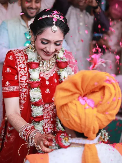 A beautiful candid moment during the wedding rituals. The bride's smile and makeup are absolutely glowing.