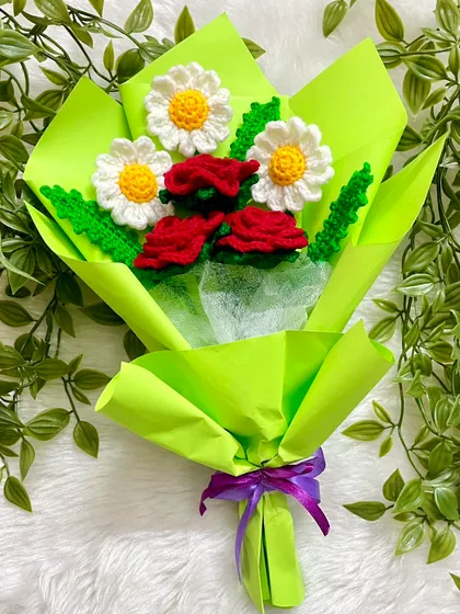 The finished red rose and daisy bouquet, all wrapped up in bright green paper with a purple ribbon. It’s such a cheerful and lovely color combination.