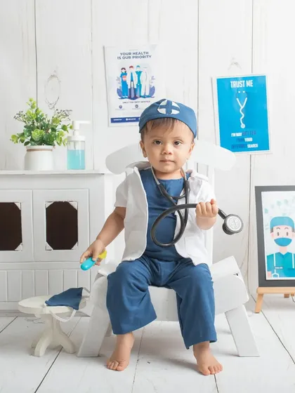 The little doctor is in. A full-body shot showing off his adorable doctor costume and the fun, detailed setup of his "clinic."