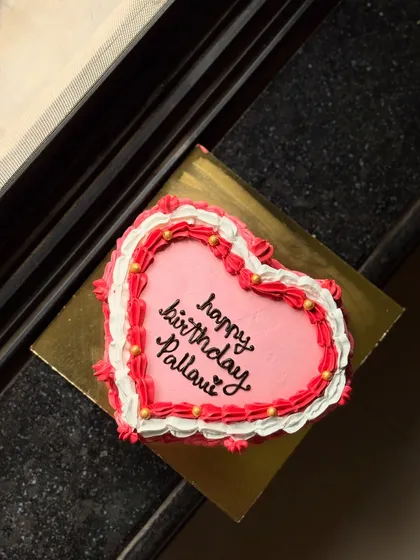 A sweet pink and red heart-shaped birthday cake for Pallavi. The piped border gives it a classic, vintage feel.