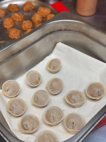 Dumplings being prepped by hand before service.