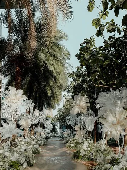 The magical walkway for the 'White Wonderland' event. We lined the path with giant, handcrafted dandelions and other paper flowers, creating an ethereal, dreamlike journey for the guests.