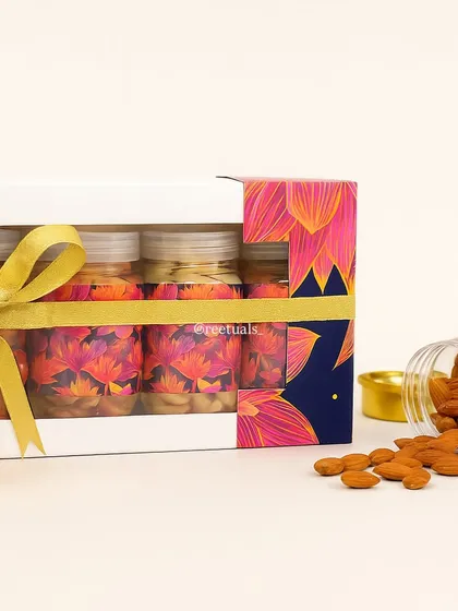 A taste of the festive season. This Diwali hamper features jars of premium almonds and cashews, presented in a vibrant box with a lotus-themed design and tied with a golden ribbon.