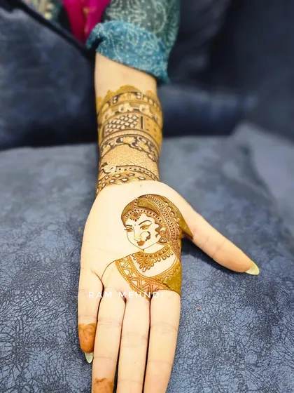 A single bride portrait on the palm, paired with an architectural design on the arm. This shows how we can mix different styles to create a cohesive and personal bridal mehndi.