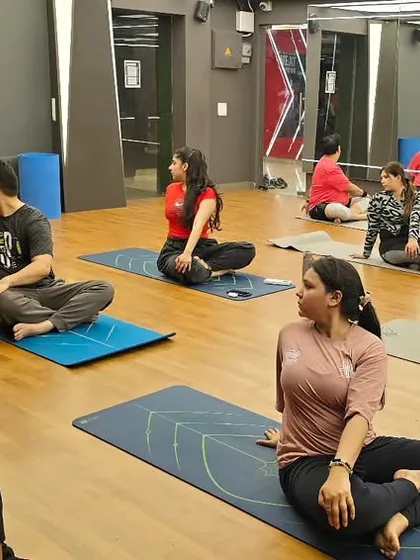 Practicing Parivrtta Sukhasana (Revolved Easy Pose). This gentle twist improves spinal mobility, aids digestion by massaging abdominal organs, and helps to calm the mind.
