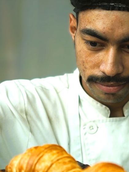 One of our talented bakers with a tray of freshly baked croissants. The care and skill that goes into each pastry is what makes them so special.