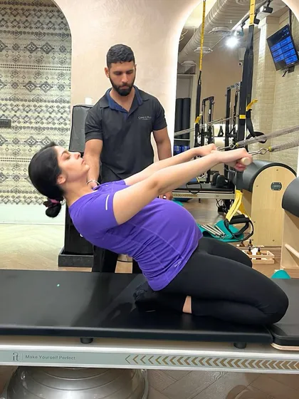 We support mothers through every stage of their journey. This client, at eight months pregnant, is building strength and comfort with a customized prenatal Pilates session, guided safely by our expert instructor.