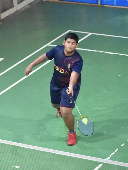 A young player executing a controlled shot at the net, showing the finesse we teach alongside power.